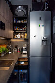 Hoher Kühlschrank in kleiner maskuliner Küche in Grau