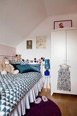 Metal bed with valance in child's bedroom with sloping ceiling
