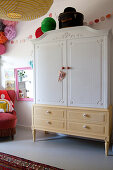 Old wardrobe painted white and yellow in child's bedroom