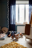 Wooden ride-on car in child's bedroom in shades of blue