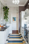 White country-house kitchen with colourful tiled floor in classic period building