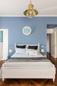 Bedroom with pale blue wall and herringbone parquet floor in period building