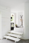 Steps leading from foyer to living space in white interior
