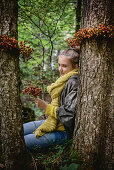Girl in woods with wreaths of rose hips
