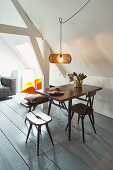 Sofa, armchair and dining area in open-plan attic interior