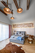 Exposed roof structure and cowhide accessories in bedroom