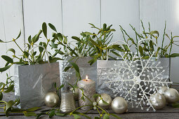 Advent-calendar bags, candle, mistletoe and baubles