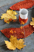 Hand-knitted mug warmers and leaf-shaped coasters for decorating autumnal table