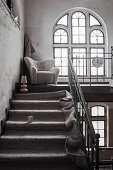 Teppich auf der Treppe zum Sessel vorm Bogenfenster in einer Fabrik