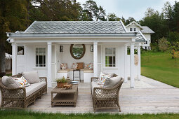 Terrasse mit Rattanmöbeln vorm Gartenhaus im viktorianischen Stil