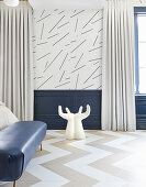 Hand-shaped chair in bedroom with blue wainscoting