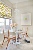 Breakfast nook in kitchen with abstract graphic art work, Roman blind and lantern lamp