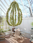 Chandelier covered in leaves in greenhouse