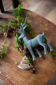 Reindeer figurine and larch twigs on wooden chair