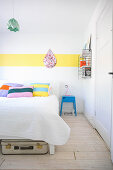 White bedroom with various accents of bright colour