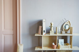 Pale wooden shelves with woven wall panel