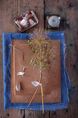 Dried garlic flowers tied together and garlic bulbs on cardboard box