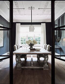 View through open glass and steel door into elegant dining room in old building