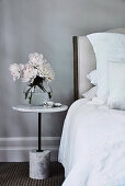 Peonies on the marble bedside table in the grey bedroom