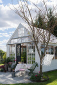 Idyllic summerhouse made from old windows in summery garden