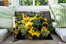 Strauß Sonnenblumen in einer Nische in gemauerter Sitzbank