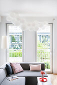 Cloud of white balloons above sofa in living room