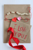 Love note on craft paper and string of lettered beads