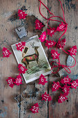 Rote Tannenbäumchen aus Filz mit Zahlen und eine Postkarte mit Hirsch