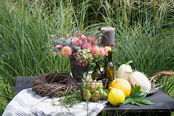 Autumn arrangement with pumpkins, pears and flower arrangement on the garden table