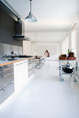 Open-plan kitchen in minimalist interior with white floor