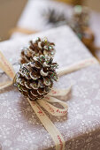 wrapped Christmas gift decorated with pine cones