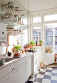 Weiße Küche mit Schachbrettfliesen und Balkontür