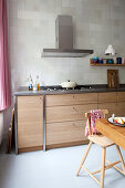 Küchenzeile in Holzoptik, darüber gefliester Wand in Wohnküche