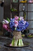 Bunch of blue hyacinths and tulips with burlap ribbon