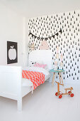 White bed and black-and-white wallpaper in Scandinavian-style child's bedroom