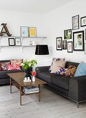 Gray sofas with differently patterned pillows and picture gallery in a living room