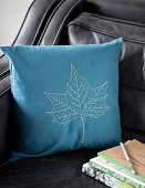Embroidered cushion cover with leaf motif