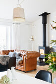 Weihnachtlich dekorierter Wohnraum mit Holzofen und Ledercouch