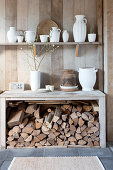 Shelf with white jugs above the console with firewood