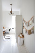 Study in white with a wooden pearl necklace as a wall decoration