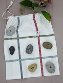 Sacks with ribbons and painted stones as a game