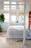 A flower necklace on the wall in a bedroom on a houseboat