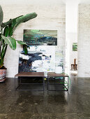 Two cubic coffee tables in front of pictures leaning against the wall