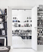 A view through an open double door into a bedroom with bookshelves