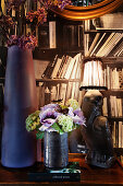 Vases and vintage table lamp in front of a bookshelf