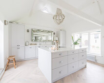 White fitted kitchen with island counter in converted barn