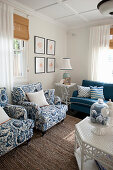 Polstersessel, Beistelltisch und Sofa im Wohnzimmer mit blauen Farbakzenten