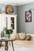 Old cupboard and rustic accessories in living room with grey walls