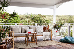 Cushions on wooden bench, stool and rattan chair on terrace