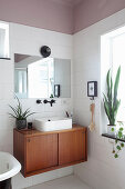 Countertop sink on mid-century cabinet in bathroom with dusky-pink ceiling